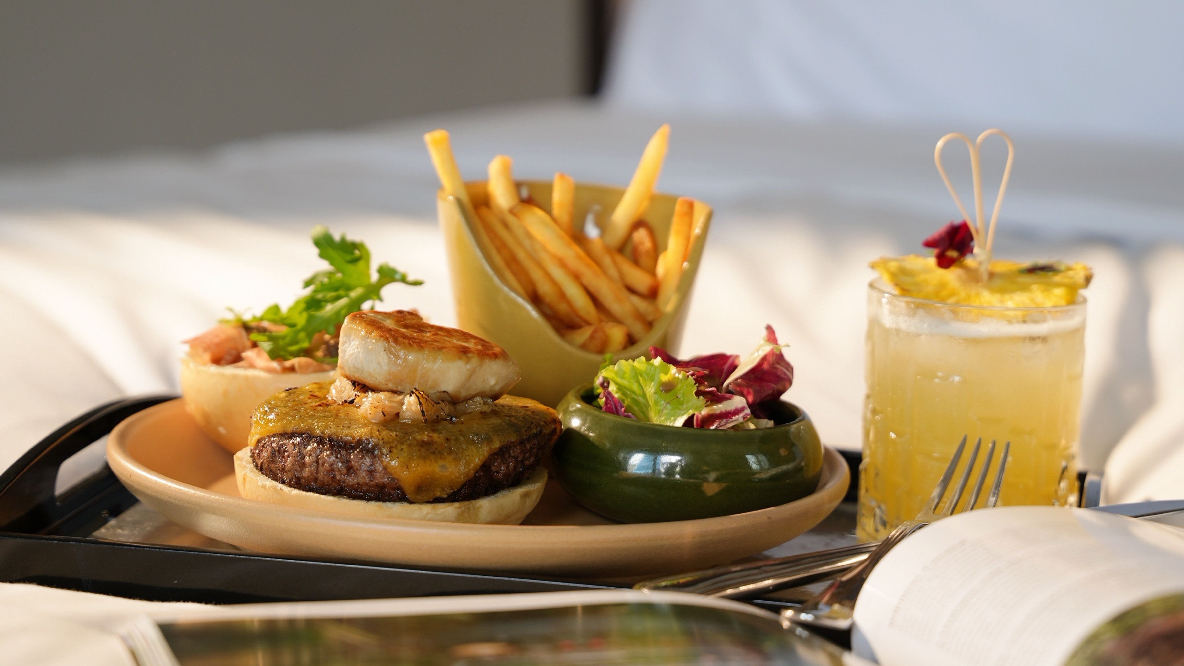 A safata amb aliments com ara hamburgueses, patates fregides i una beguda, que suggereix un ambient de menjar.