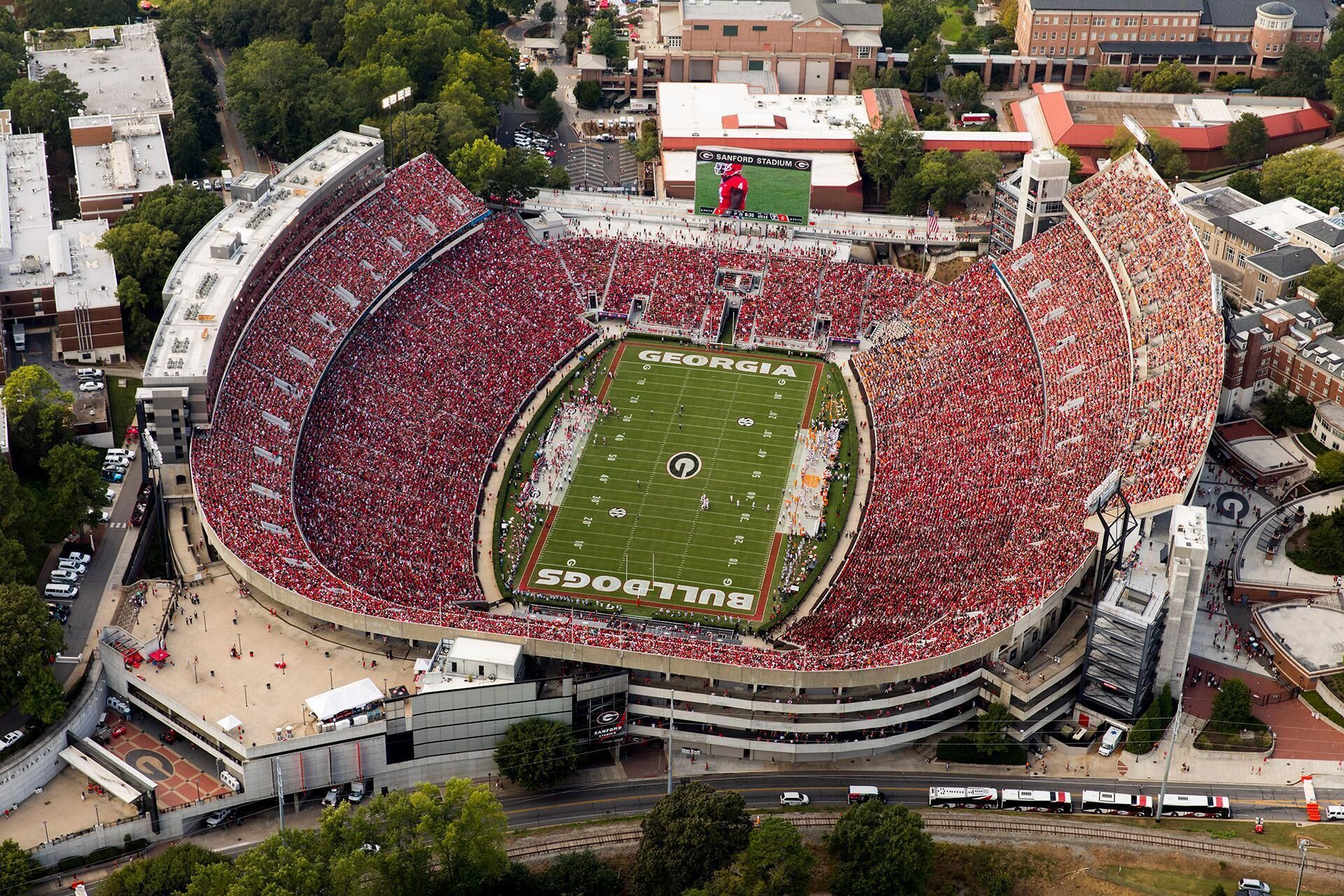 A stadium with a football field surrounded by a large crowd of spectators.