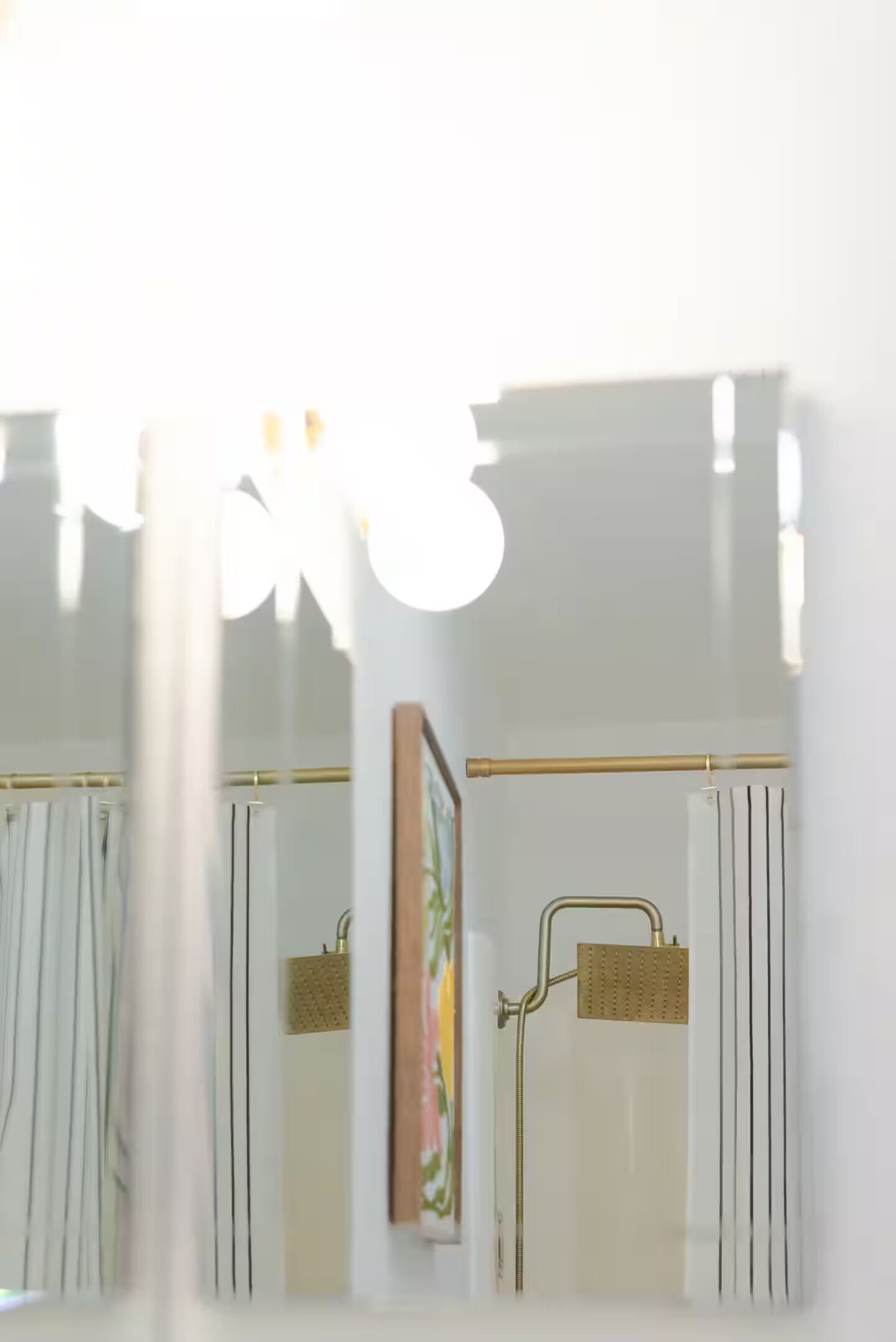 A bathroom with a shower, a towel rack, and a framed picture on the wall.