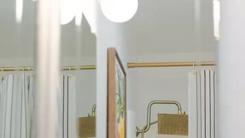 A bathroom with a shower, a towel rack, and a framed picture on the wall.