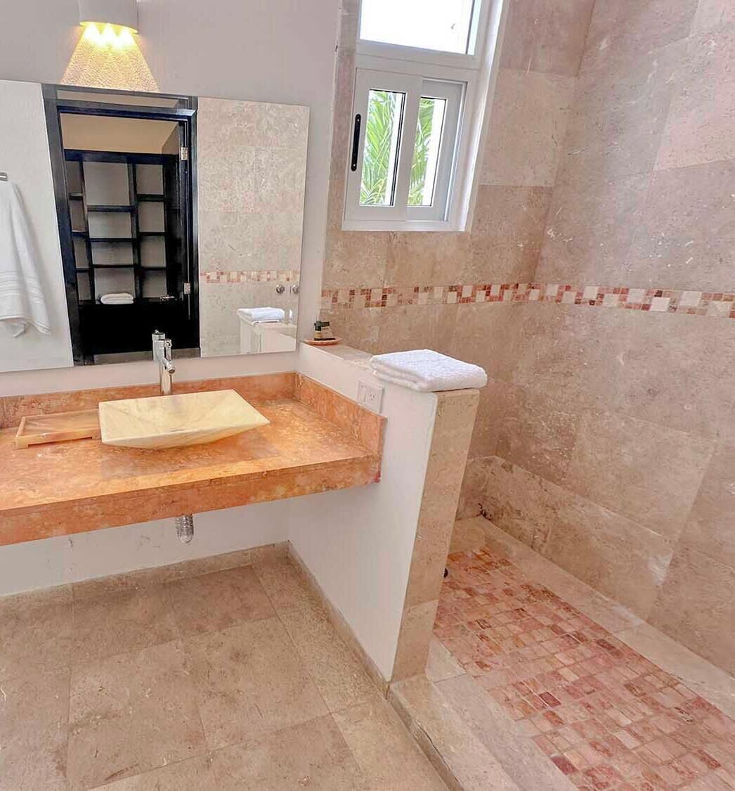 Une salle de bain avec un meuble-lavabo en bois, un évier, un miroir et une fenêtre.