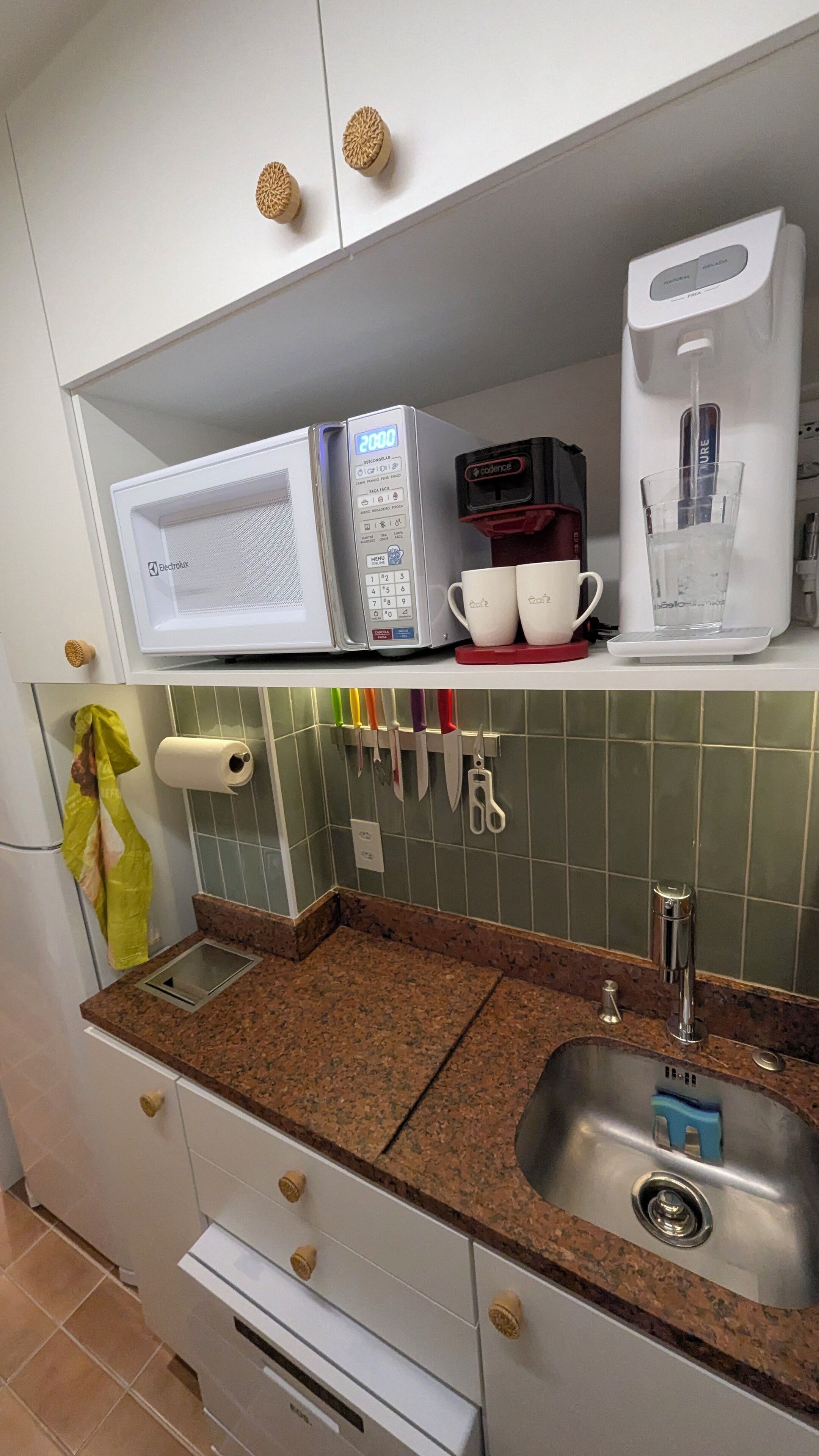 Eine Küche mit Mikrowelle, Kaffeemaschine und Geschirr auf der Arbeitsfläche.