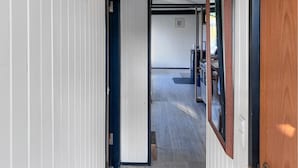 Un couloir au plancher de bois menant à une cuisine.