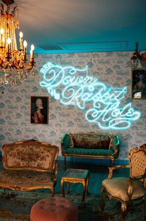 A room with vintage furniture, a chandelier, and a neon sign. - Pool + Pickleball + Firepit | IN TOWN | Sleeps 8 (Round Top)