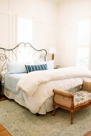 A bedroom with a bed, a nightstand, a lamp, a chair, and a window. - Pool + Pickleball + Firepit | IN TOWN | Sleeps 8 (Round Top)