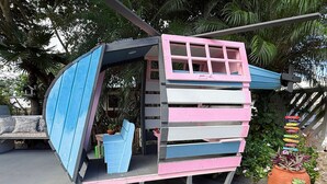 Une maison de jeu colorée, à plusieurs niveaux, dotée d’un toboggan, de sièges intégrés et d’une petite table.