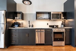 Una cocina moderna con refrigerador de acero inoxidable, microondas integrado, horno y lavavajillas.