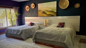 Un dormitorio con dos camas, un ventanal grande y un cuadro en la pared.