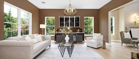 A spacious living room with a large sofa, a coffee table, and a view of a kitchen and dining area.