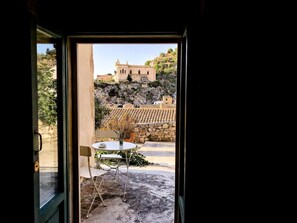 Une chambre avec vue sur un bâtiment historique, un mur en pierre et un toit recouvert de tuiles.