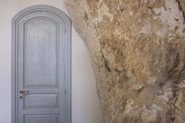 Une porte au design simple, située à côté d’un mur à la texture particulière.