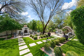 A well-maintained garden with a patio area, outdoor furniture, and a decorative fire pit.