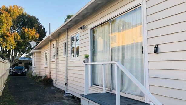 A single-story mobile home with a front porch, a sliding glass door, and a small attached garage. - 4 Beds Including 1 Sofa Bed in 1 Bedroom+1 Lounge (Auckland)