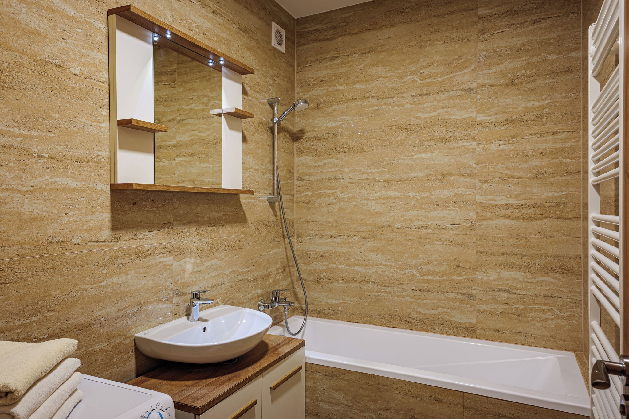 Un baño con lavamanos, espejo y ducha.