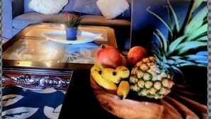 Ein Wohnzimmer mit einer Couch, einem Couchtisch und einer Obstschale.