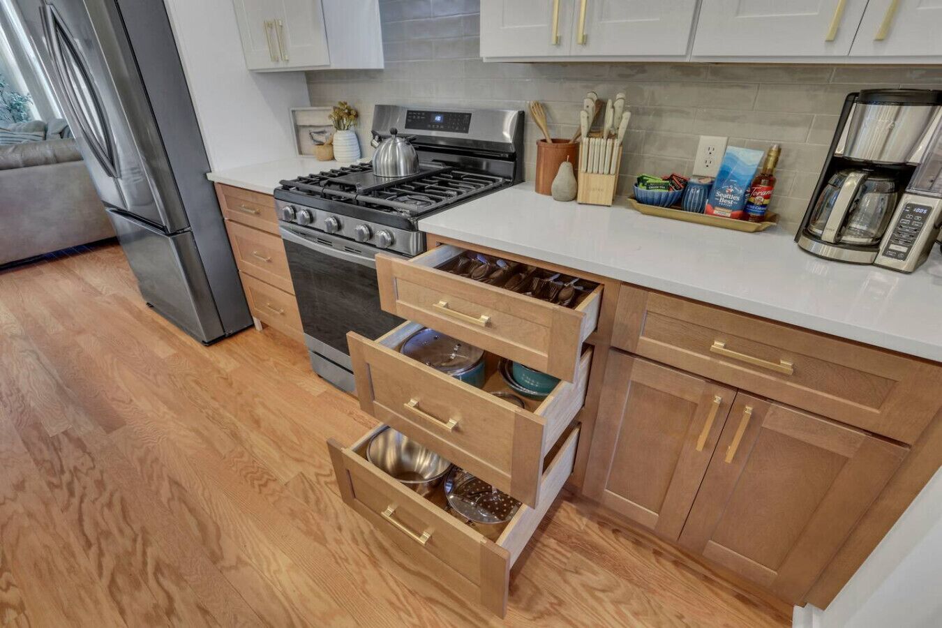 A modern kitchen with stainless steel appliances, wooden cabinets, and a countertop with kitchen utensils.