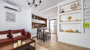 A modern living room with a brown leather sofa, a wooden coffee table, and a kitchen in the background. - Le loft sur rivière (Dijon)