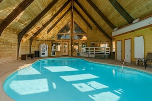 An indoor swimming pool with wooden beams and a high ceiling. - Gunslinger Gateway Red Lodge (Red Lodge)