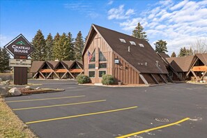 A Chateau Rouge building with a parking lot and multiple chalet-style cabins. - Gunslinger Gateway Red Lodge (Red Lodge)