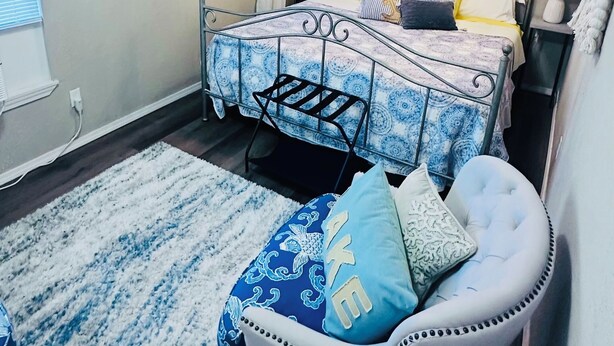 Ein Schlafzimmer mit Bett, Nachttischen, einer Chandelieber und einem Wandteppich.