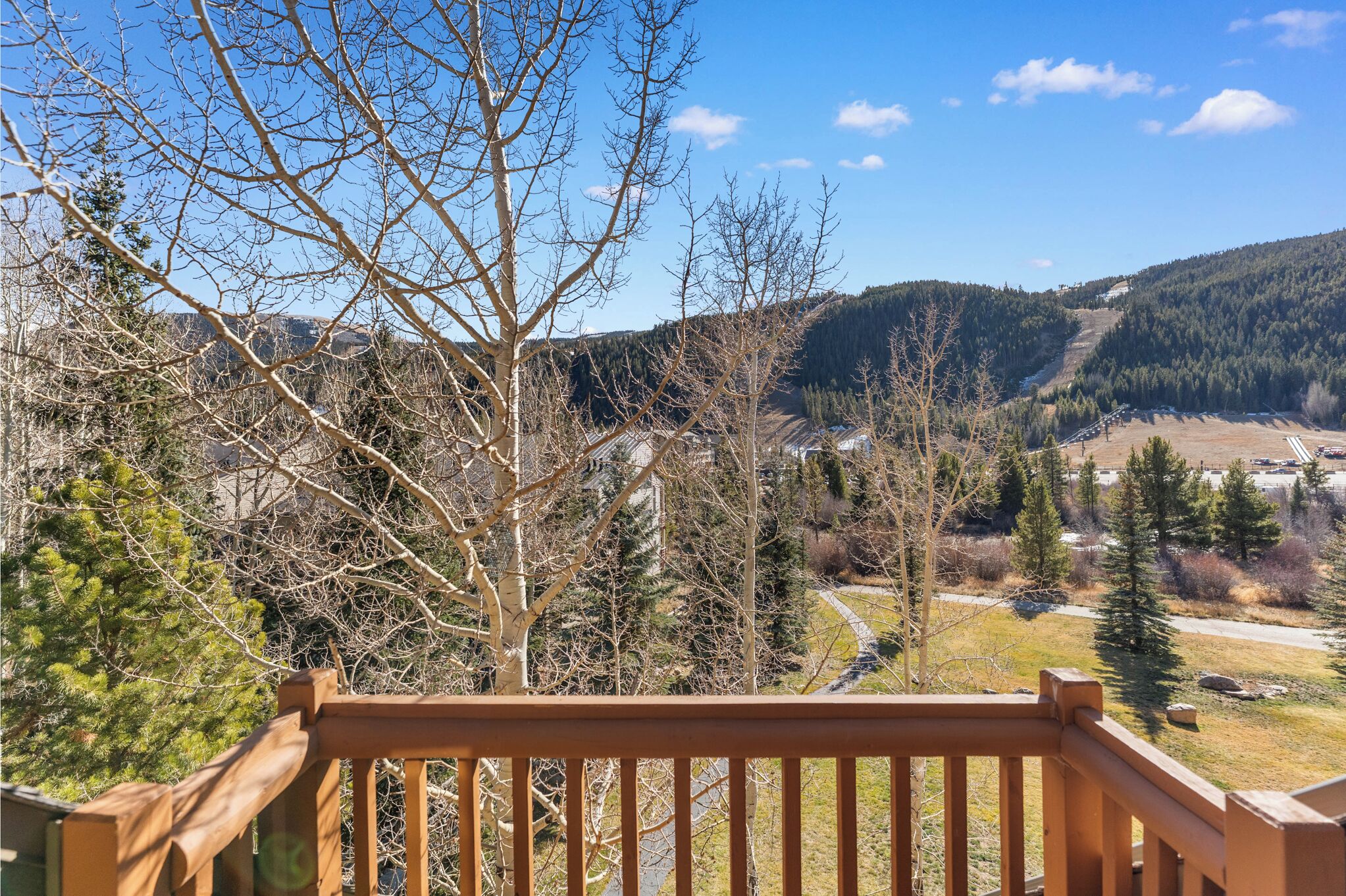 A wooden deck overlooking a mountainous landscape with a clear sky.