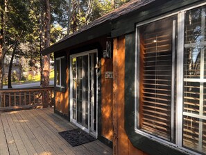 Un bâtiment en bois doté de grandes fenêtres et d’une terrasse.