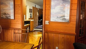 A wooden interior with a dining area, kitchen, and a hallway leading to another room. - Beautiful 3-bedroom cabin in Lake Arrowhead perfect for relaxing getaways! (Lake Arrowhead)