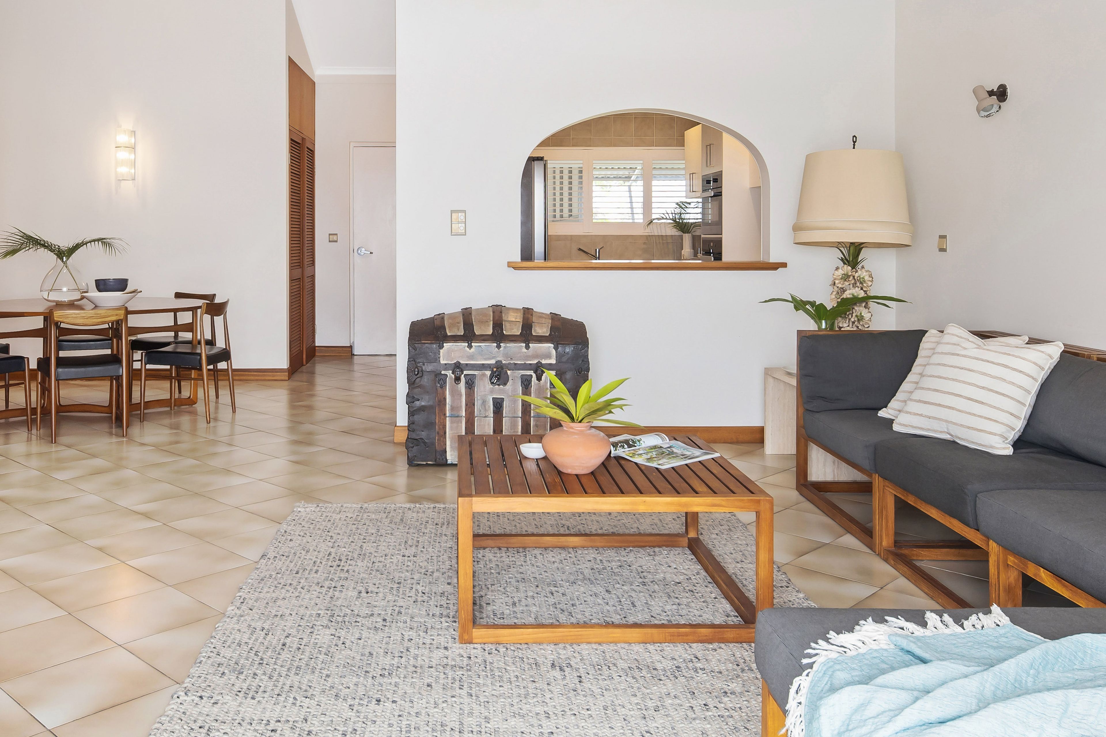 A modern living room with a sofa, coffee table, and dining area.