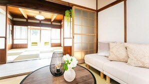 Una habitación de estilo japonés tradicional con suelo de tatami, bajo techo de madera y puertas correderas shoji.