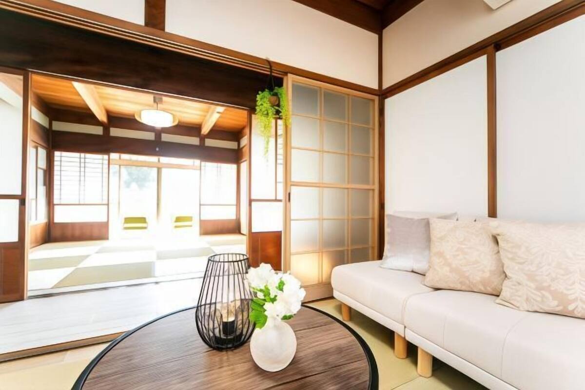 A traditional Japanese-style room with tatami flooring, a low wooden ceiling, and sliding shoji doors.