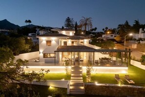 A modern house with a patio, a swimming pool, and a view of the surrounding landscape. - All About Santa Ana Villa (Marbella)