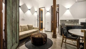 A modern interior with a sofa, ottoman, dining table, and chairs. - Bloom Resort Bali by BaliSuperHost (Bali)