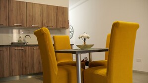 Een eethoek met gele stoelen, een tafel en een klok aan de muur.