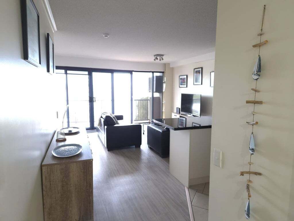 A modern apartment with a kitchen, dining area, and a balcony.