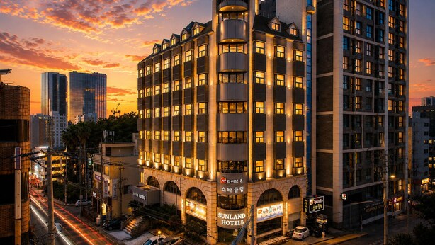 Un hotel con varios pisos, una entrada destacada y un letrero que indica que es un Sunland Hotel.