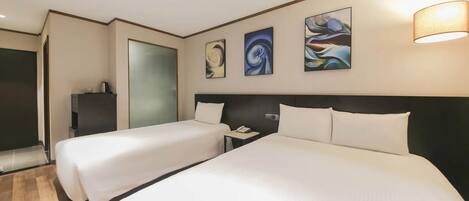 A hotel room with two beds, a nightstand, a phone, and abstract wall art.