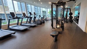 Ein Fitnessstudio mit Laufbändern, Crosstrainern und Gewichten.