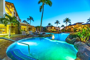 A hotel pool area with a clear blue pool, lounge chairs, and palm trees. - Wailea Beach | Oceanfront 3 BR | Car Incl. w/ 6+ Nights | WBV-PH505 by KBM (Wailea)