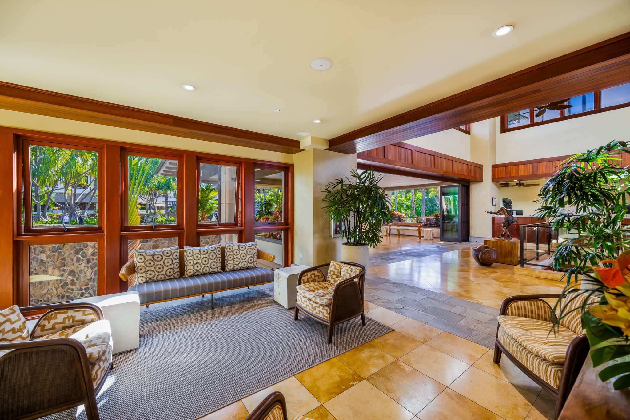 A spacious lobby with a seating area, large windows, and indoor plants.