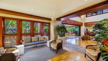 A spacious lobby with a seating area, large windows, and indoor plants.