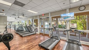 Una palestra con tapis roulant, cyclette e vogatore.
