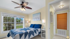 A bedroom with a bed, a ceiling fan, a window with blinds, and a door with a window. - Ideal location - 2bed/1bath near the beach & shops (Port Charlotte)