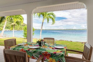 A table set for dining with a view of the ocean and palm trees. - Paradise (Bora Bora)