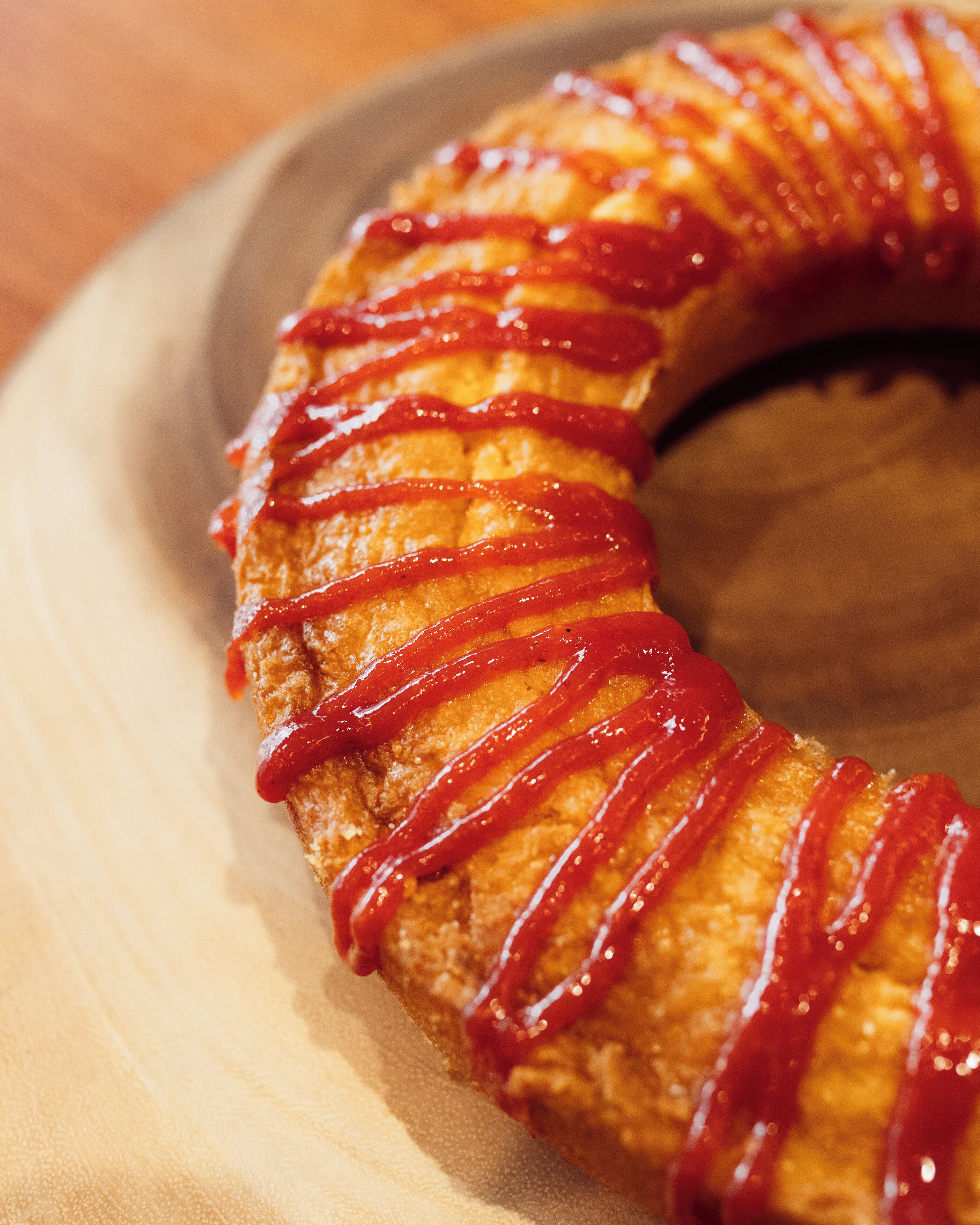 Um close-up de um alimento com um padrão em espiral e cobertura vermelha brilhante.