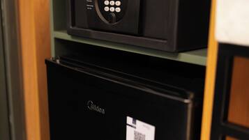 Ein schwarzer Kühlschrank mit einem darunterliegenden Gefrierfach, eine schwarze Mikrowelle darüber und ein QR-Code-Aufkleber am Kühlschrank.