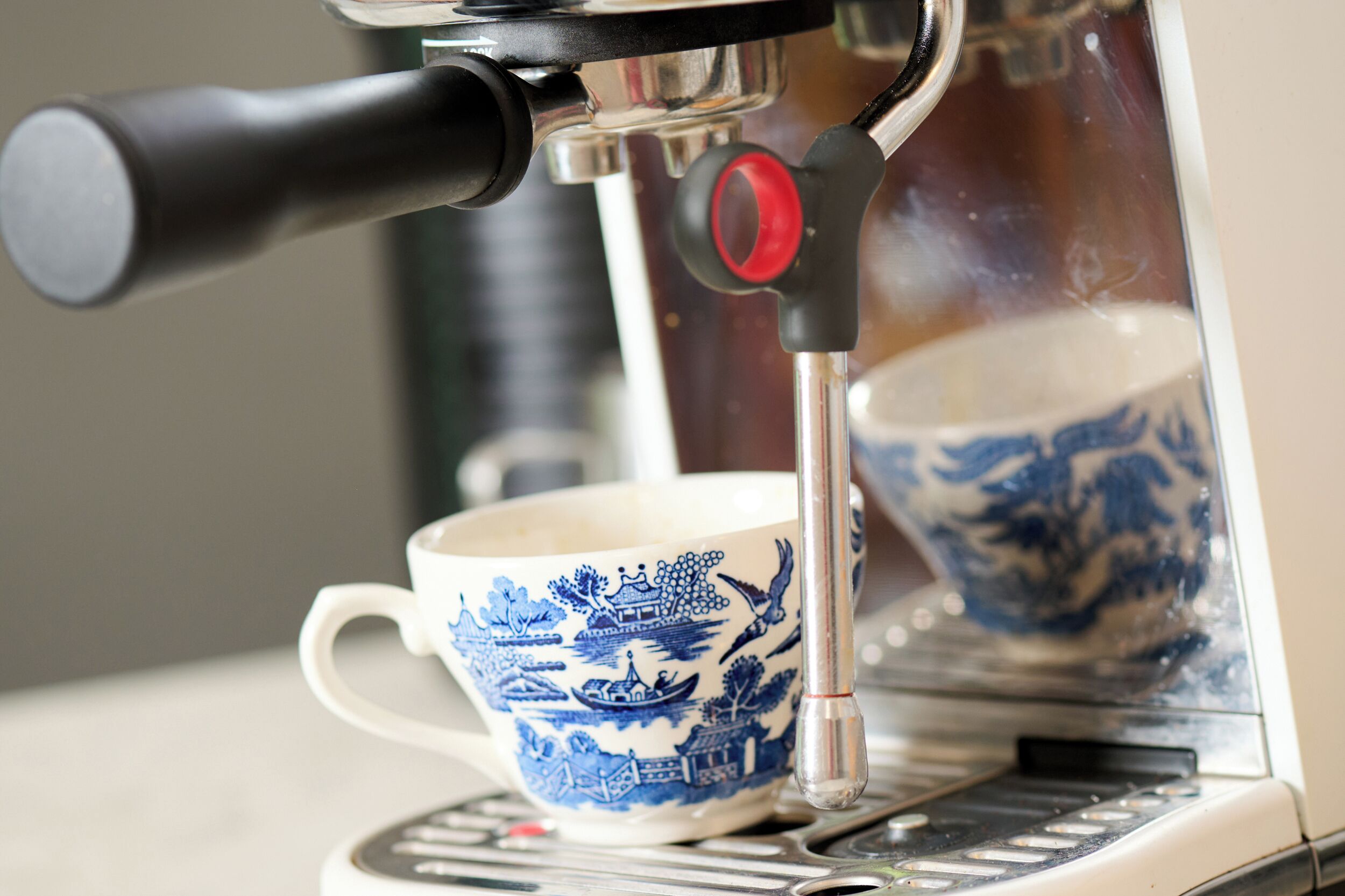A coffee machine with a cup of tea.