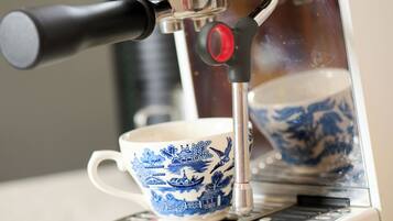 Een koffieapparaat met een kop thee.