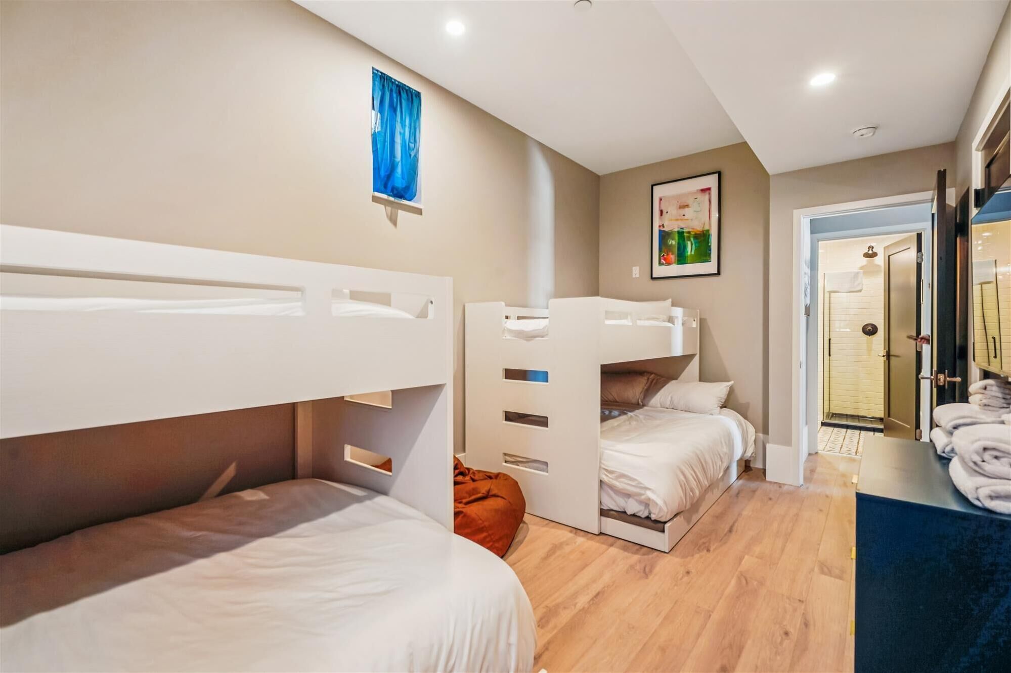 Een slaapkamer met stapelbedden, een badkamer met douche en een hal met handdoeken.