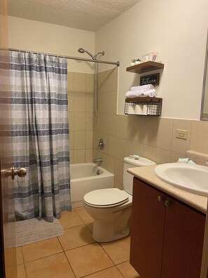 Een haardroger, handdoeken, zeep, toiletpapier