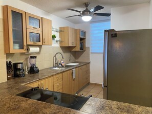 A kitchen with wooden cabinets, a stainless steel refrigerator, a double sink, a coffee maker, and a blender. - Nido Azul -Oceanview Condo 2B/2B + 2 Parking +Wifi. Cabo Rojo-Puerto Rico (Boquerón)